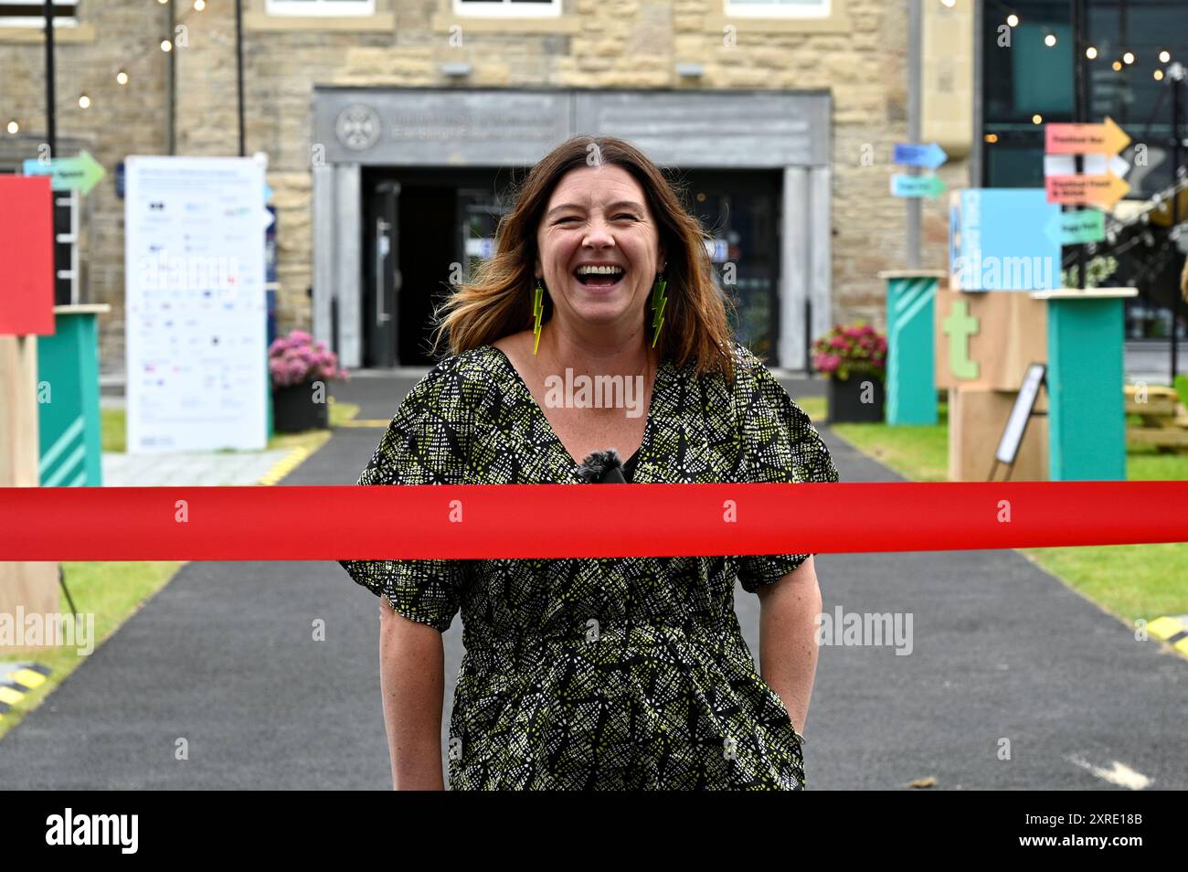 Edinburgh, Schottland, Großbritannien. August 2024. Edinburgh International Book Festival: Jenny Niven, Direktor des Buchfestivals, schneidet die Bürokratie bei der offiziellen Eröffnung des diesjährigen Buchfestivals am Futures Institute ab. Quelle: Craig Brown/Alamy Live News Stockfoto