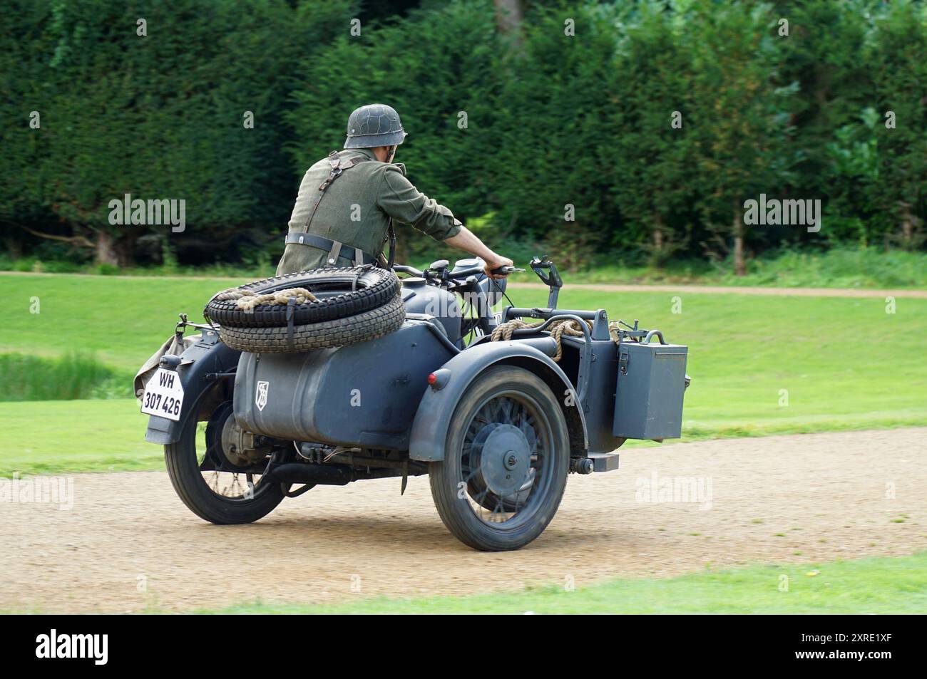Deutscher Vintage-Motorrad und Beiwagen aus dem 2. Weltkrieg, der von einem Mann in Keimuniform gefahren wird Stockfoto