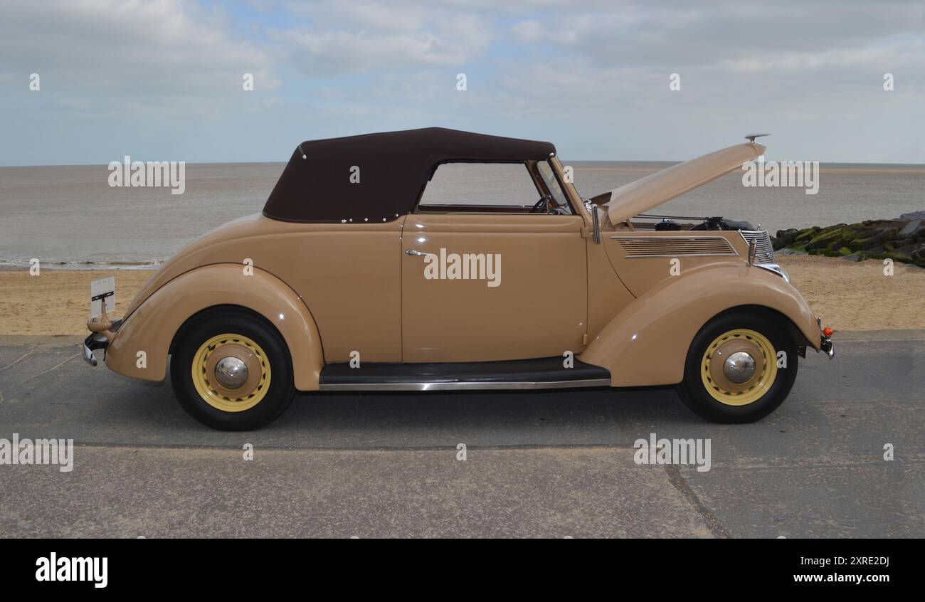 Vintage Ford Club Cabriolet parkt an der Strandpromenade Strand und Meer im Hintergrund. Stockfoto