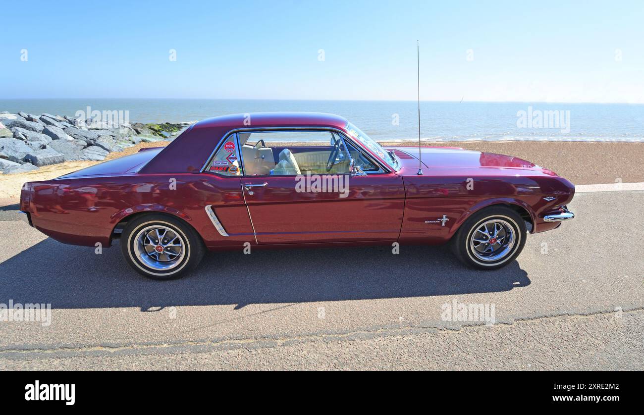 Classic Purple Ford Mustang geparkt am Strand und Meer im Hintergrund. Stockfoto