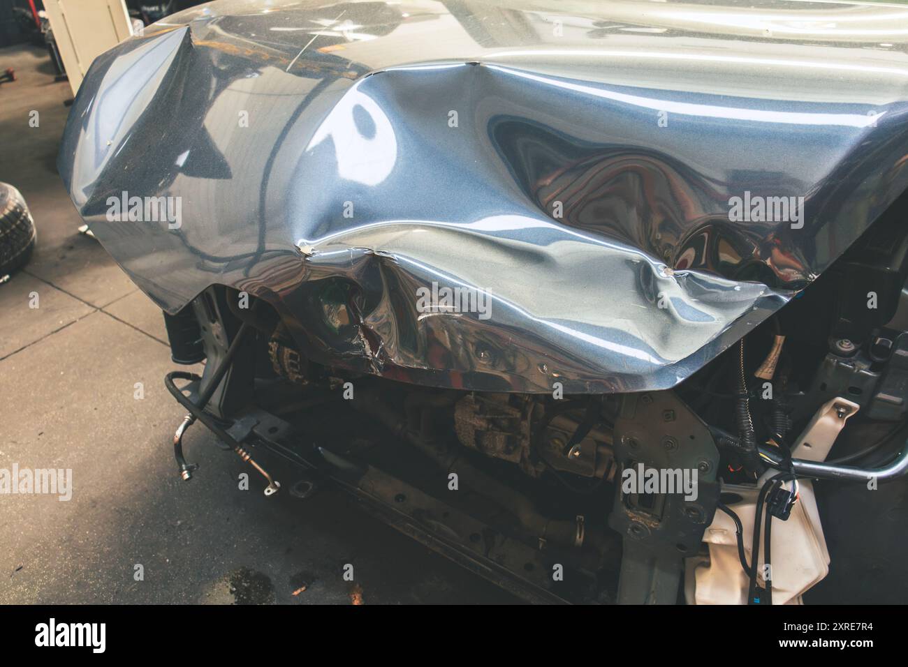 Draufsicht auf den vorderen Teil des Fahrzeugs nach einem Unfall in einer Autoreparatur. Stockfoto