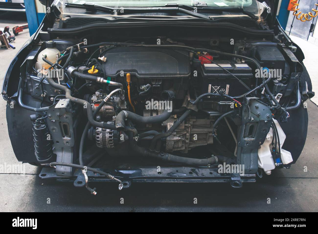 Draufsicht auf den vorderen Teil des Fahrzeugs nach einem Unfall in einer Autoreparatur. Stockfoto
