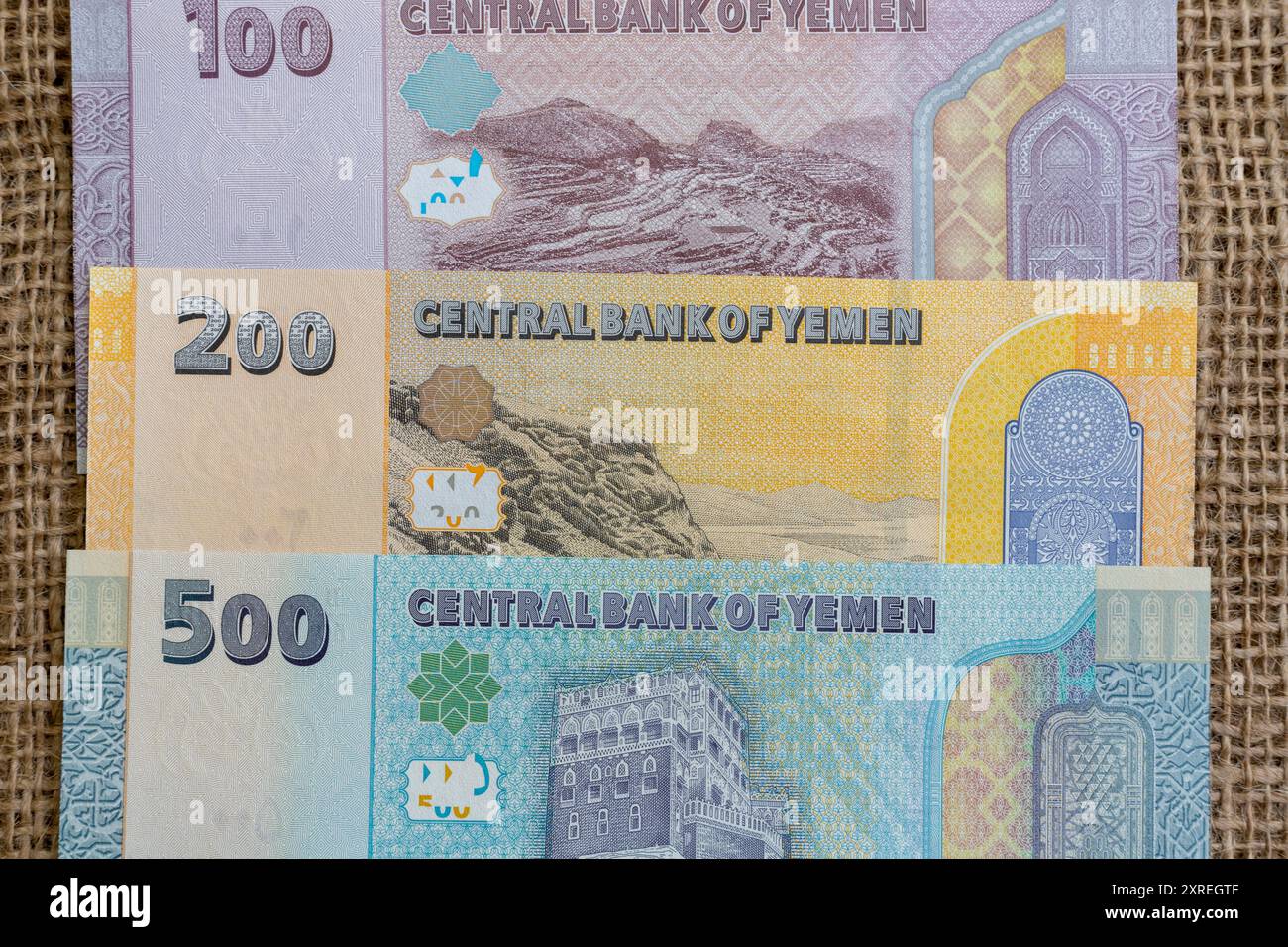 Jemenitische Rial-Banknoten von 500, 200 und 100 auf einem Hintergrund mit Sackleinen Stockfoto