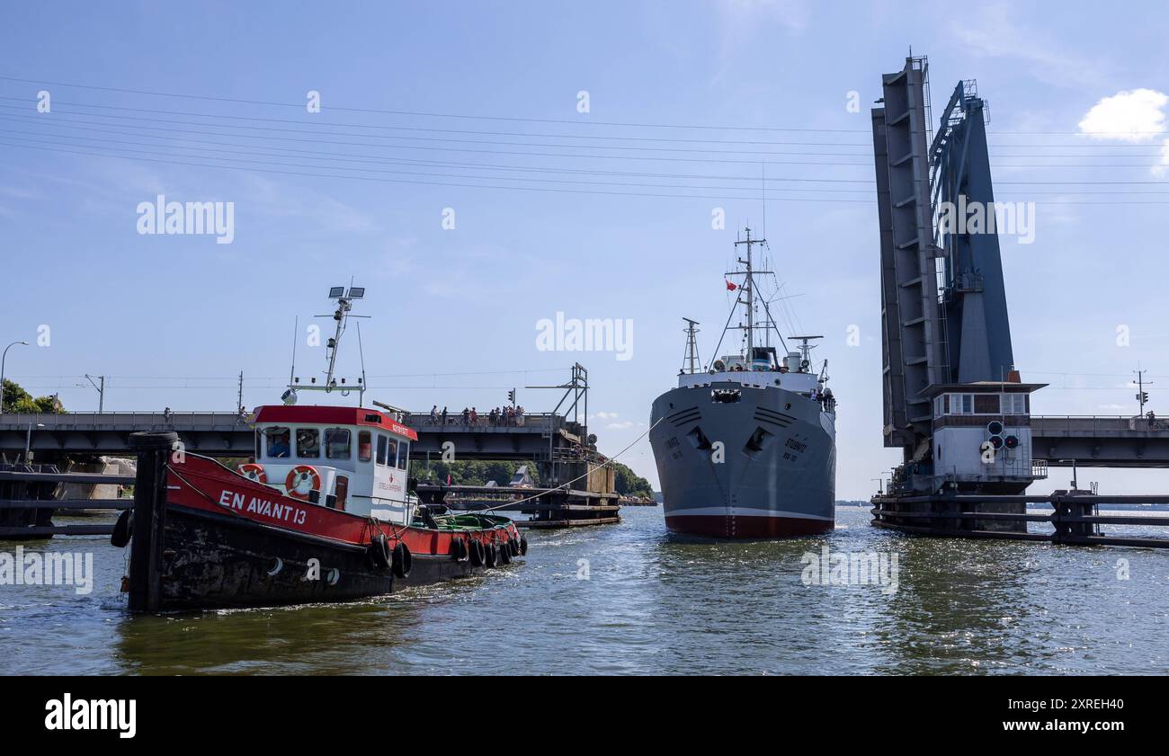 Frau Stubnitz geht wieder auf Fahrt der Werftschlepper EN AVANT 13 bugsiert das KTS STUBNITZ aus dem Schiffslift durch die Ziegelgrabnbruecke in Stralsund. Das Kulturschiff und Industriedenkmal wurde von der Strela Shiprepair GmbH repariert und erhält einen neuen Schiffs-TUEV. Die 60 Jahre alte STUBNITZ ist ein ehemaliges Kuehl- und Transportschiff KTS der DDR-Hochseefischerei. Stralsund Mecklenburg-Vorpommern Deutschland *** MS Stubnitz setzt wieder in See der EN AVANT 13 Werft Schlepper MANÖVRIERT die KTS STUBNITZ aus dem Schiffslift durch die Ziegelgrabnbruecke in Stralsund die Kulturshalle Stockfoto