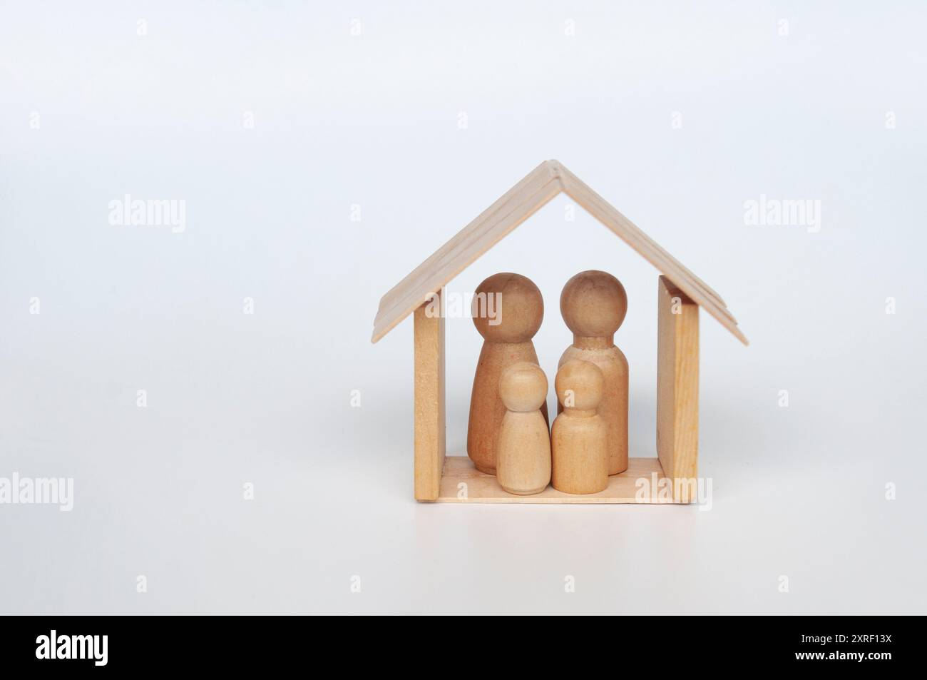 Hölzerne Familienpuppen in einem Minihaus mit anpassbarem Platz für Ideen. Stockfoto