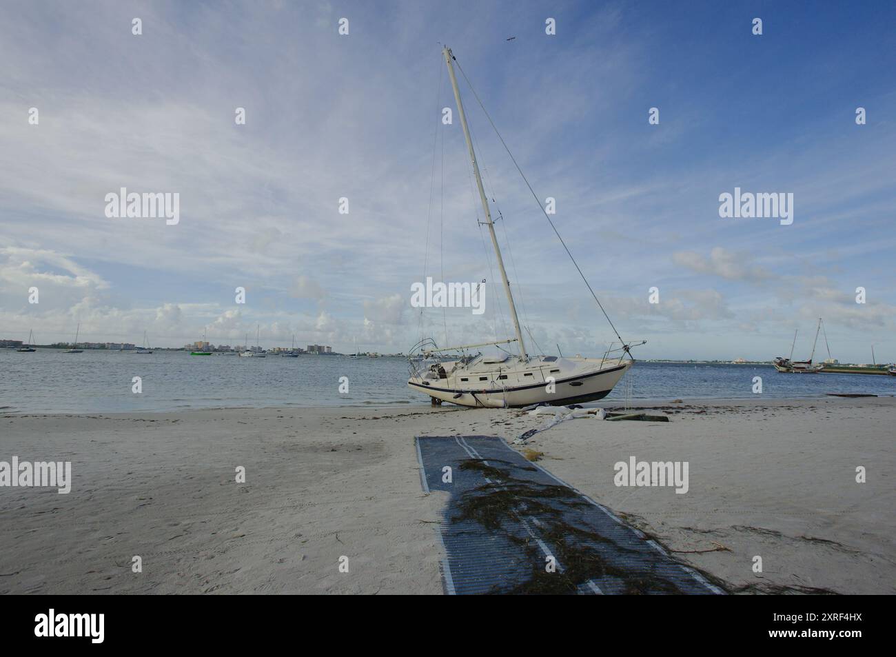 Strandsegelboote nach einem Sturm am Gulfport Beach Florida. Boote und Yachten wurden nach starkem Wind aus der Bucht von Boca Ciega eingespült. Am Frühen Morgen Sonne Stockfoto