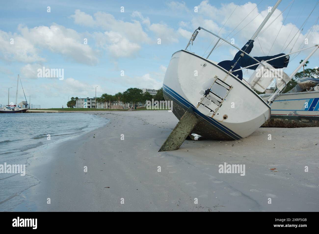 Strandsegelboote nach einem Sturm am Gulfport Beach Florida. Boote und Yachten wurden nach starkem Wind aus der Bucht von Boca Ciega eingespült. Am Frühen Morgen Sonne Stockfoto