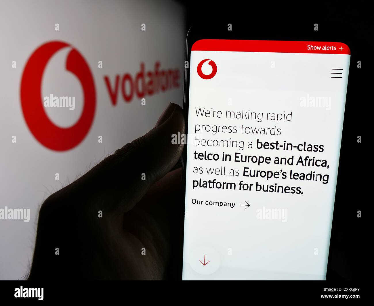 Person mit Smartphone mit Webseite des britischen Telekommunikationsunternehmens Vodafone Group plc mit Logo. Konzentrieren Sie sich auf die Mitte des Telefondisplays. Stockfoto