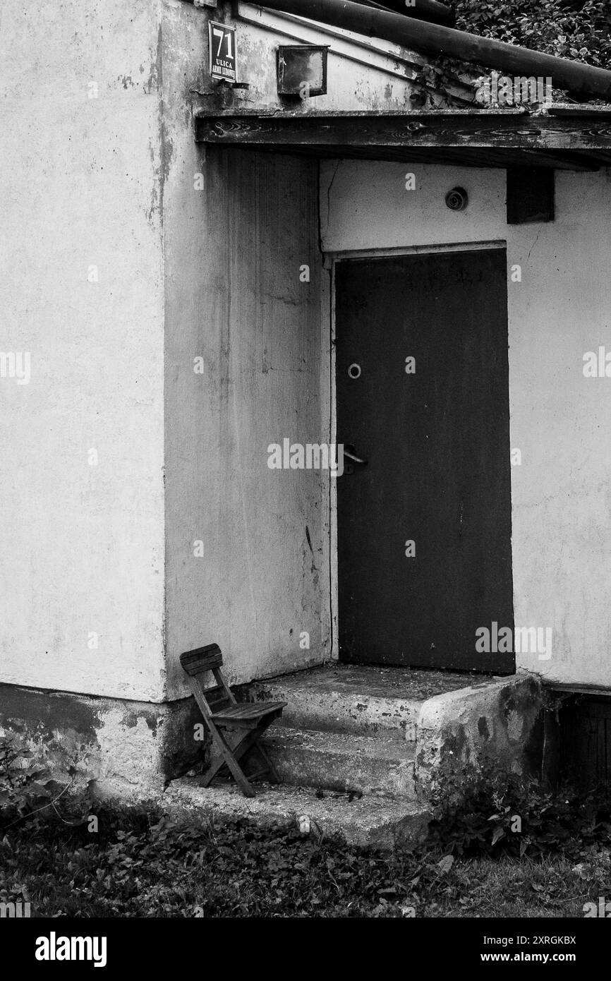 Vergessener Kinderstuhl vor einem verlassenen Haus in Opoczno, Polen. Armut, Postkommunismus, Verfall, vergessen. Schwarzweißbild Stockfoto