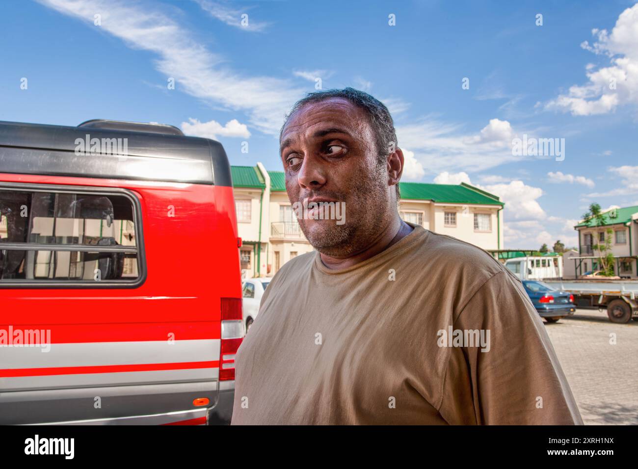 arabischer Erwachsener, männlicher mittlerer Alter, der legere Kleidung auf dem Hof eines Wohnkomplexes trägt Stockfoto