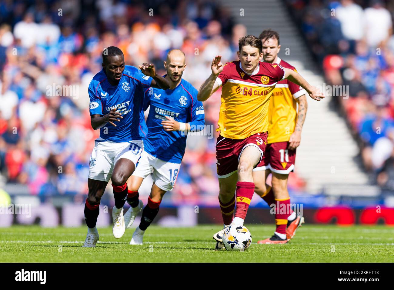 Glasgow, Schottland. August 2024. Steve Seddon (3 – Motherwell) forscht unter Druck von Mohamed Diomande (10 – Rangers) Václav Černý (18 – Rangers) Rangers vs Motherwell – William Hill SPFL Credit: Raymond Davies / Alamy Live News Stockfoto
