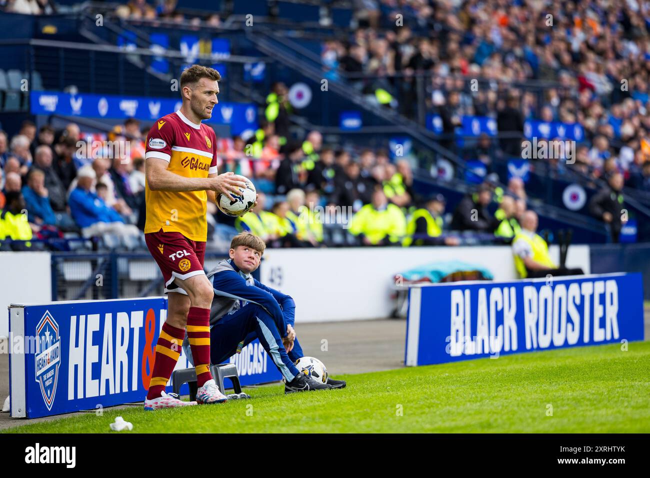 Glasgow, Schottland. August 2024. Stephen O’Donnell (2 – Motherwell) wird von einem Balljungen beobachtet, wie er A Throw Rangers vs Motherwell spielt – William Hill SPFL Credit: Raymond Davies / Alamy Live News Stockfoto