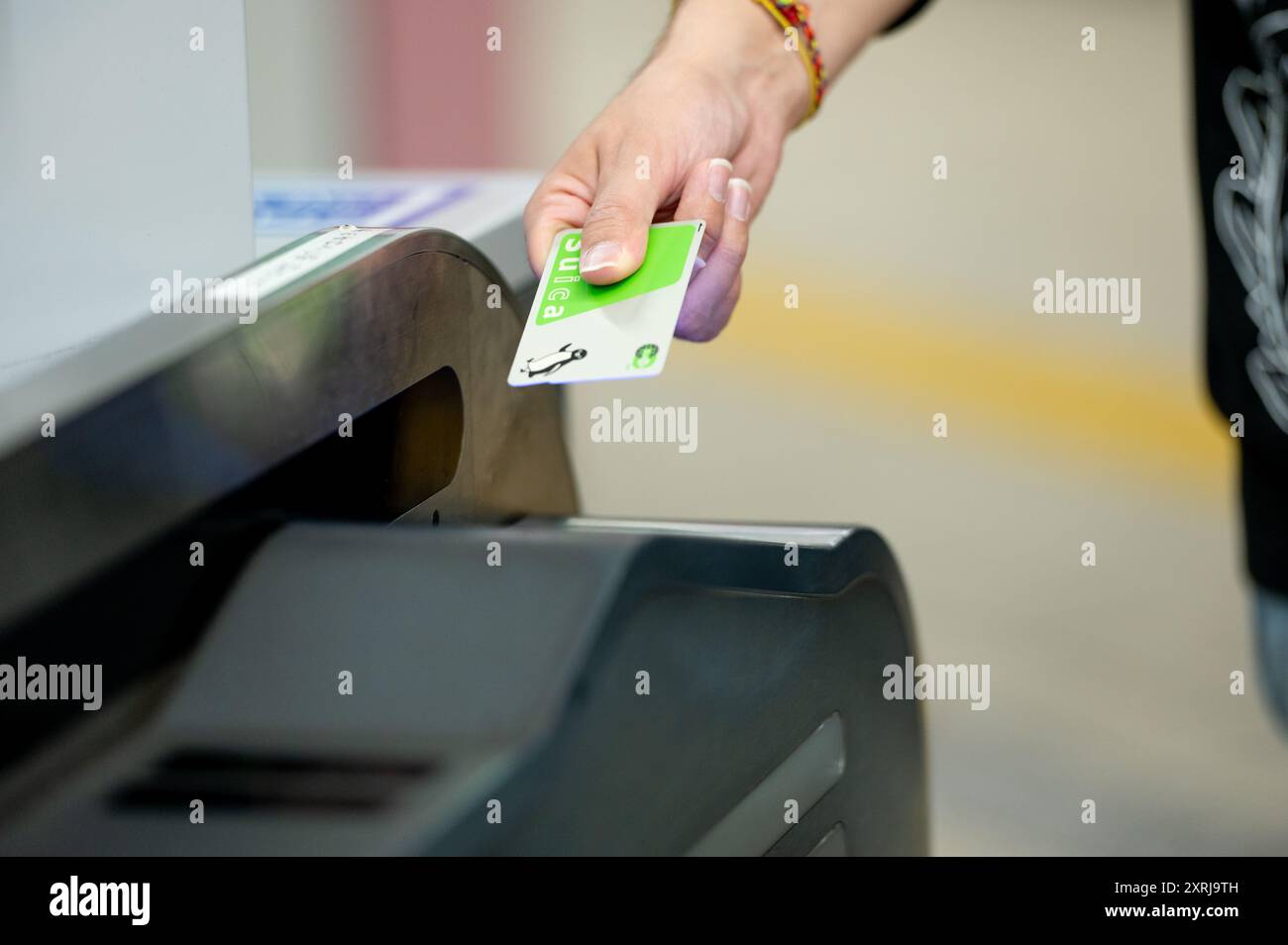 Nahaufnahme einer Person mit einer kontaktlosen Karte an einem Ticketschalter für öffentliche Verkehrsmittel, die moderne und effiziente Pendelmethoden zeigt. Stockfoto