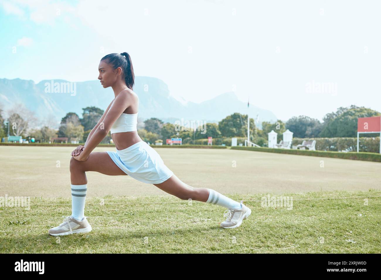 Frau, Stretchbein und Outdoor-Match auf dem Feld, Aufwärmen und Netball-Spieler zur Vorbereitung. Person, Fitness und Bewegung für Flexibilität oder Muskeln Stockfoto