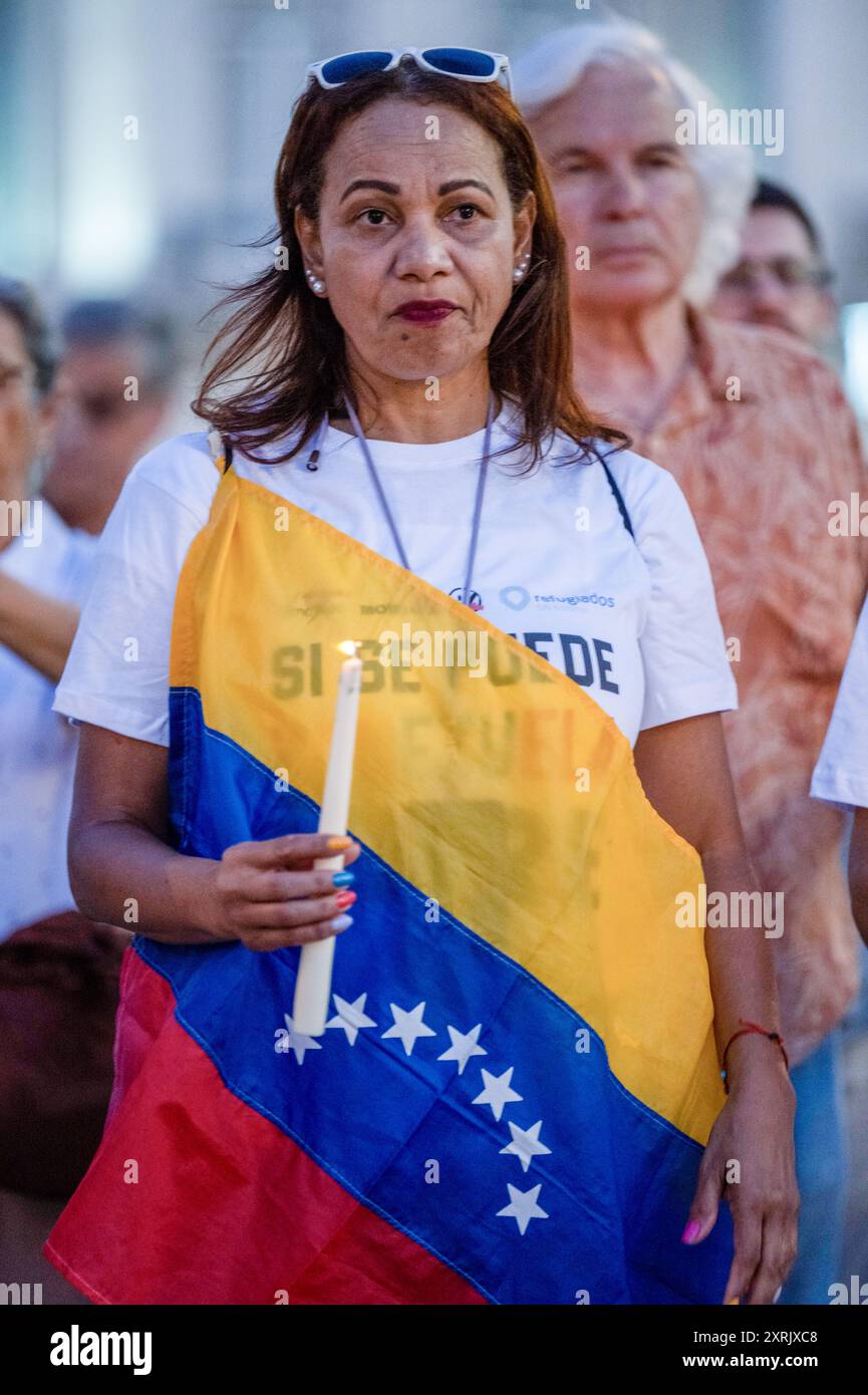 Lissabon, Portugal. August 2024. Ein Demonstrant, der ein T-Shirt mit politischen Slogans trägt und in eine Flagge gewickelt ist, hält während einer Kundgebung auf dem Restauradores-Platz eine Kerze. Die Venezolaner in Lissabon beschlossen, ihre Stimme zu erheben, um zu protestieren und die willkürlichen und repressiven Maßnahmen abzulehnen, die die Regierung gegenüber den Demonstranten angesichts der Kontroverse um die letzten Präsidentschaftswahlen angewandt hat, bei denen der derzeitige Präsident Nicolas Maduro Moros die Wahl gewann. Quelle: SOPA Images Limited/Alamy Live News Stockfoto