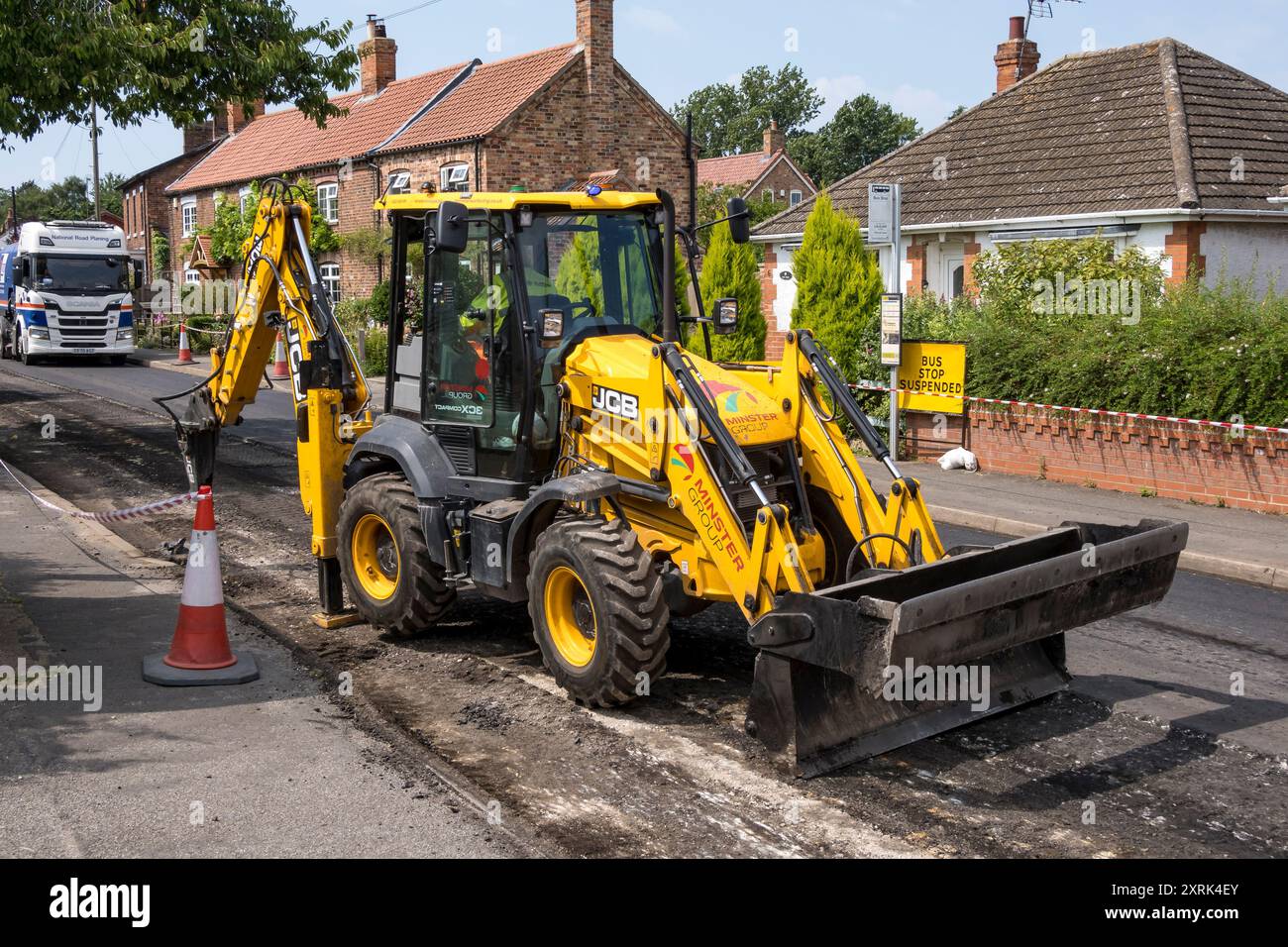Straßenbautraktor mit hinterem Hubhammer, High Street, Cherry Willingham, Lincoln, Lincolnshire, England, Großbritannien Stockfoto