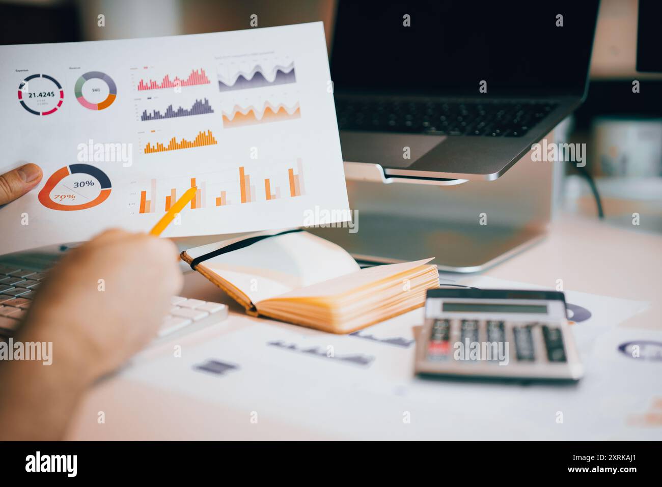 Hand zeigt auf Analysenstäbe. Finanzberichte und Berechnungen. Tabelle mit Dokumenten und Rechner. Stockfoto