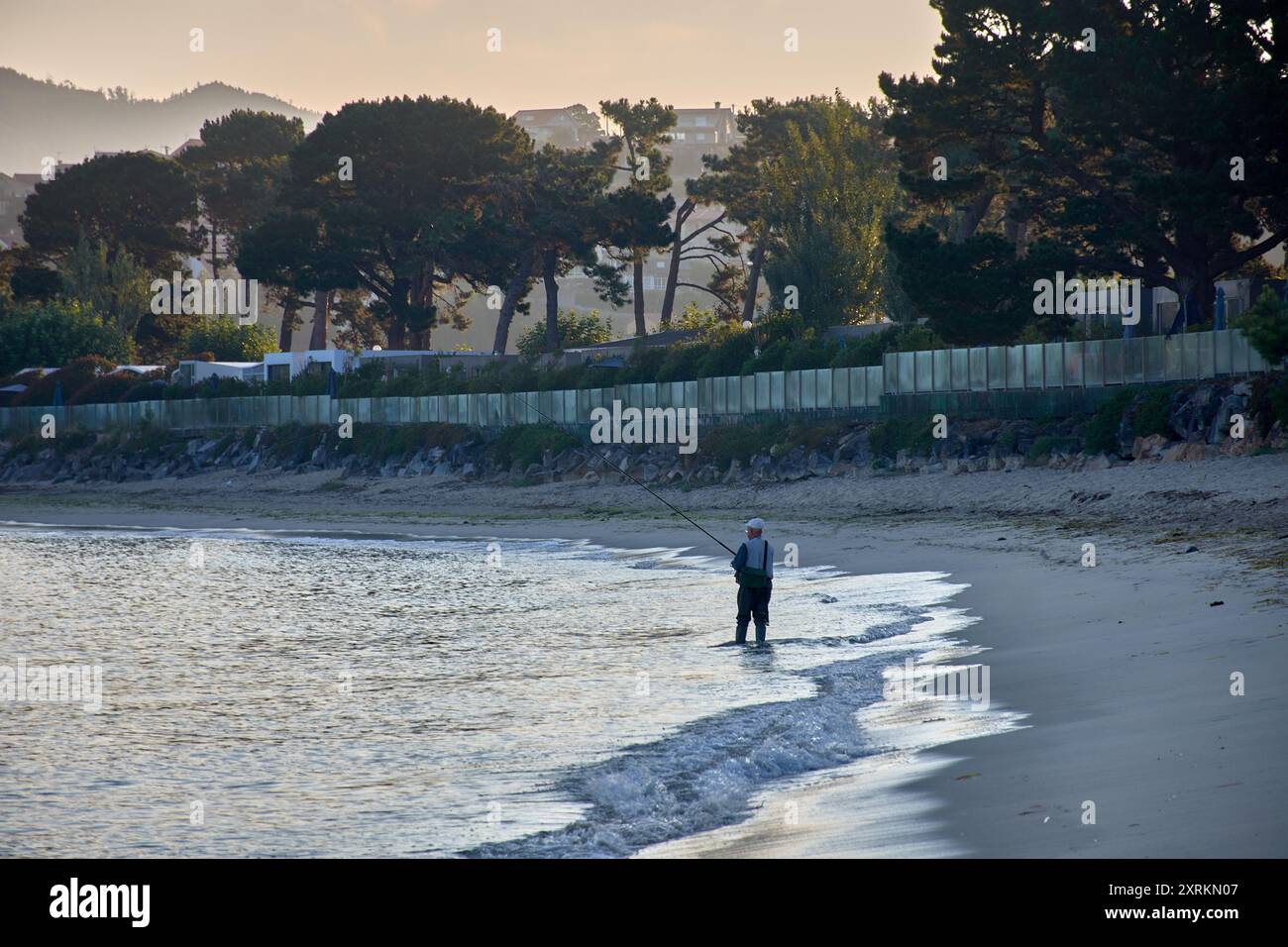 Die atemberaubende Schönheit der Playa de la Ladeira in Baiona bei Sonnenaufgang. Wenn die Sonne aufgeht, taucht ihr goldenes Licht den Sandstrand und das ruhige Wasser und schafft so Stockfoto