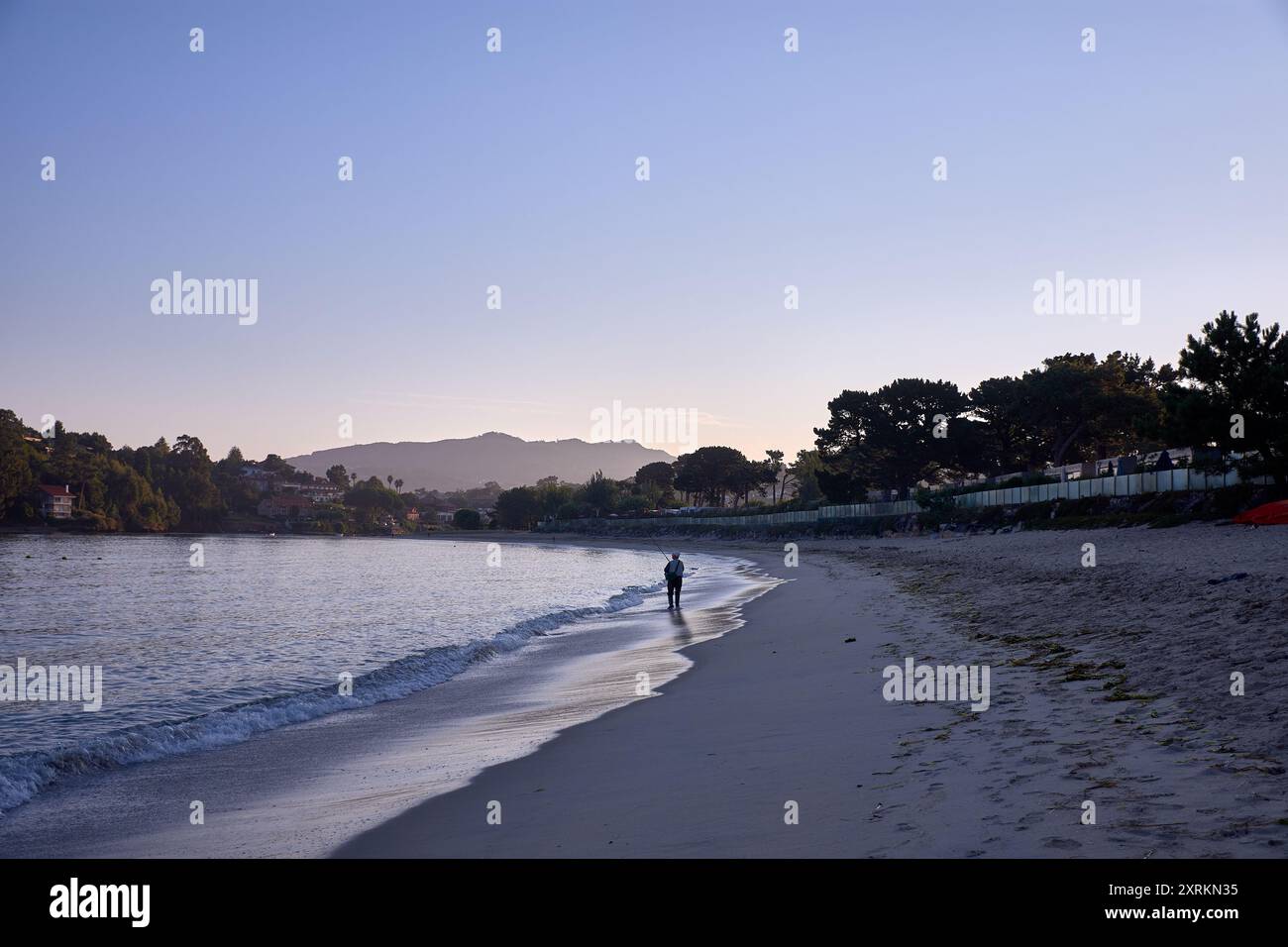 Die atemberaubende Schönheit der Playa de la Ladeira in Baiona bei Sonnenaufgang. Wenn die Sonne aufgeht, taucht ihr goldenes Licht den Sandstrand und das ruhige Wasser und schafft so Stockfoto