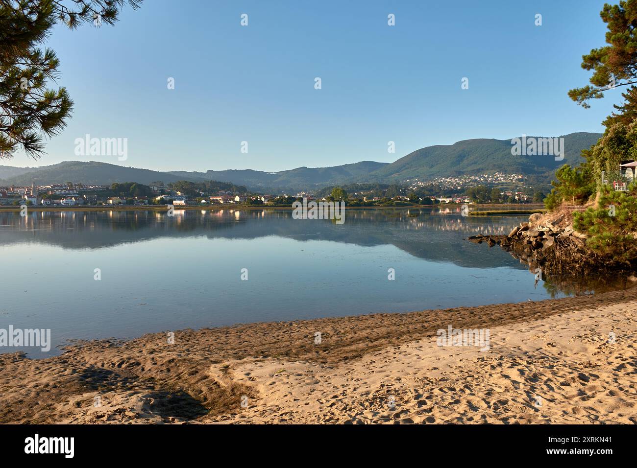 Die atemberaubende Schönheit der Playa de la Ladeira in Baiona bei Sonnenaufgang. Wenn die Sonne aufgeht, taucht ihr goldenes Licht den Sandstrand und das ruhige Wasser und schafft so Stockfoto