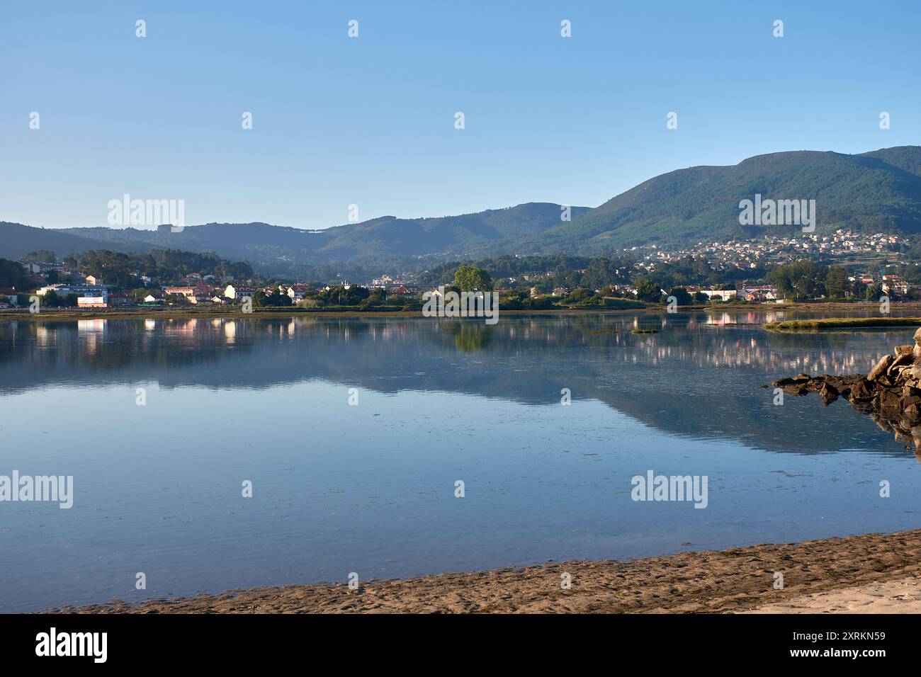 Die atemberaubende Schönheit der Playa de la Ladeira in Baiona bei Sonnenaufgang. Wenn die Sonne aufgeht, taucht ihr goldenes Licht den Sandstrand und das ruhige Wasser und schafft so Stockfoto