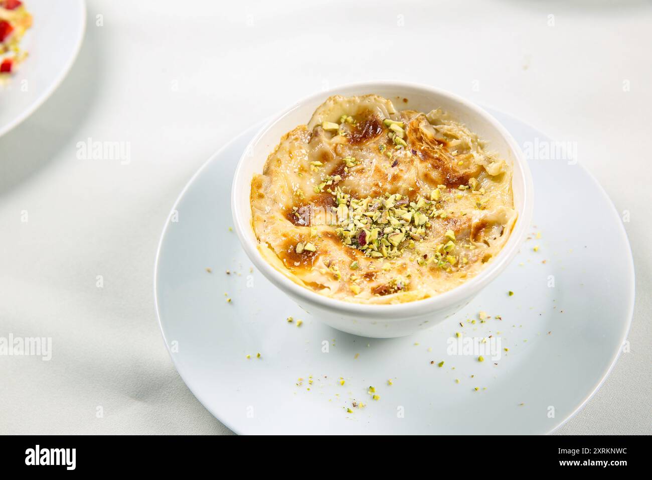 Om Ali. Draufsicht. Ägyptischer Brotpudding in einer braunen Schüssel isoliert auf weißem Hintergrund. Draufsicht. Arabisches süßes Gebäck Dessert Stockfoto