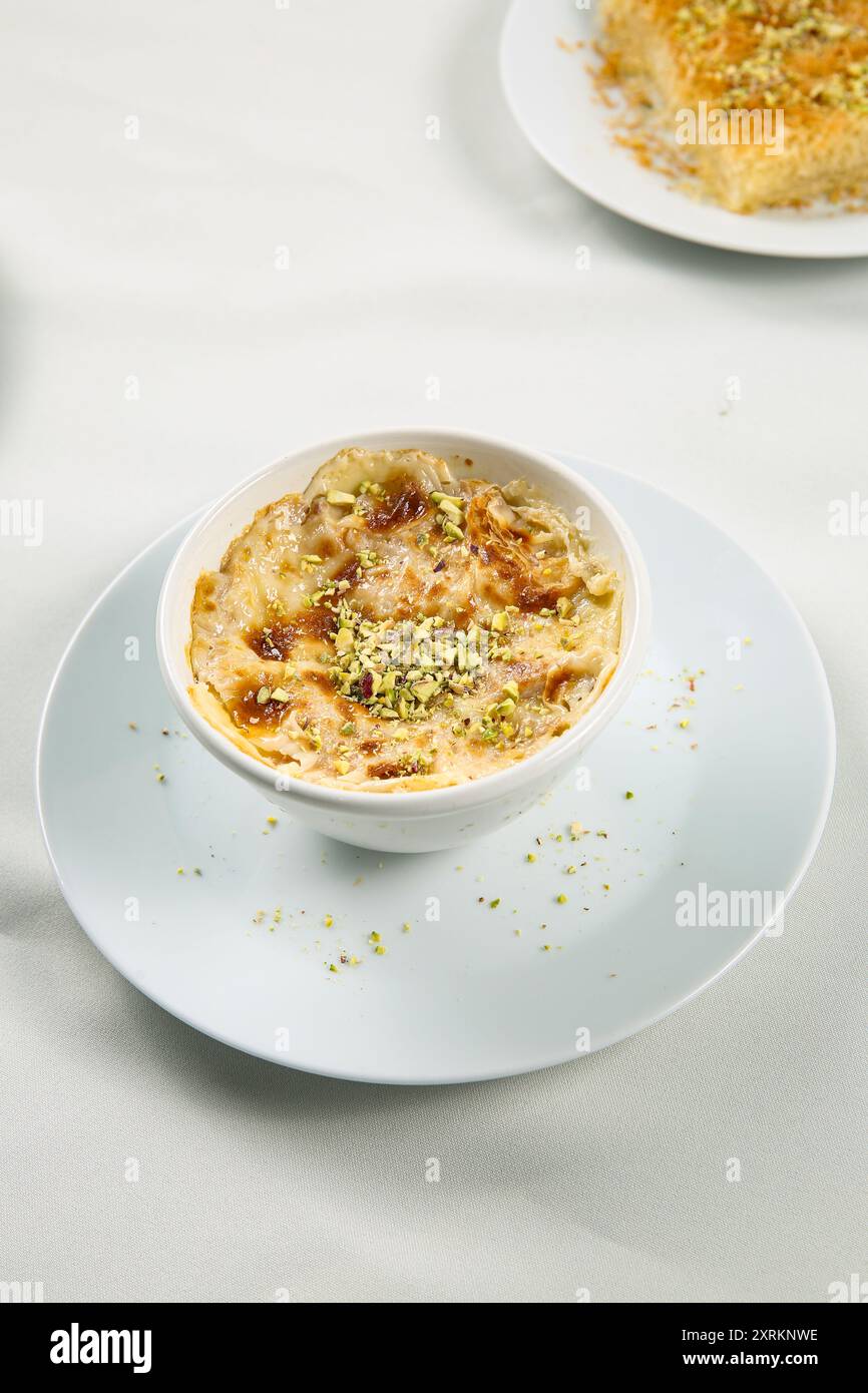 Omali. Draufsicht. Ägyptischer Brotpudding in einer weißen Schüssel isoliert auf weißem Hintergrund. Draufsicht. Arabisches süßes Gebäck Dessert Stockfoto