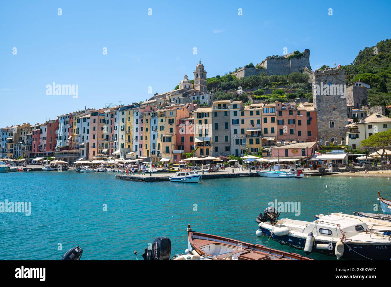 Malerischer Blick auf traditionelle helle Häuser im Hafen und Schloss auf dem Hügel in der historischen Stadt Porto Venere, Italien. Stockfoto