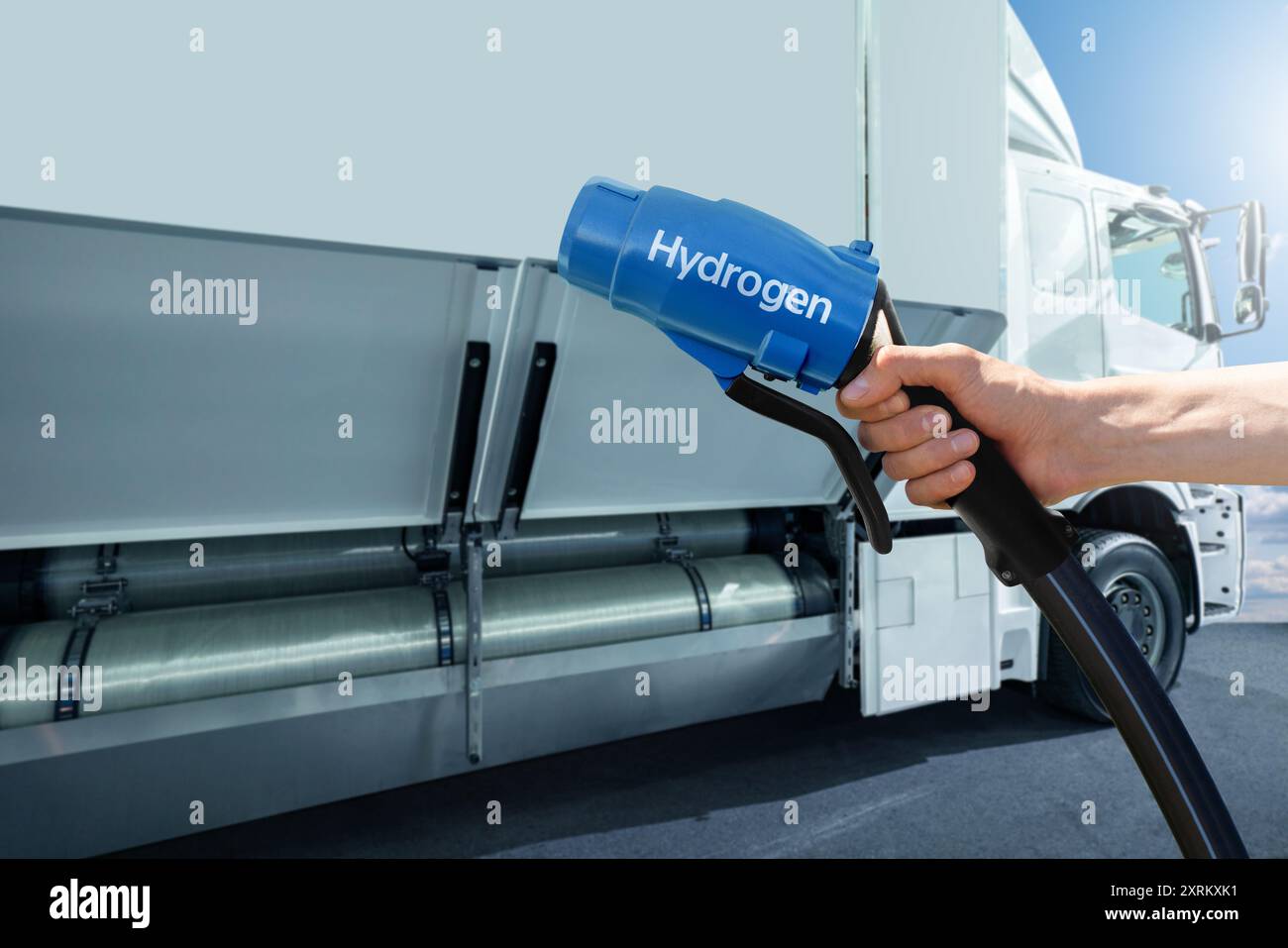 Hand mit H2-Düse auf einem Hintergrund eines Wasserstoff-Brennstoffzellen-Sattelfahrzeugs mit H2-Gasflasche an Bord. Umweltfreundliches Nutzfahrzeugkonzept... Stockfoto