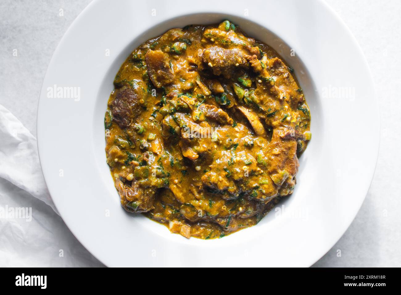 Blick von oben auf die nigerianische Ogbono-Suppe auf einem weißen ...