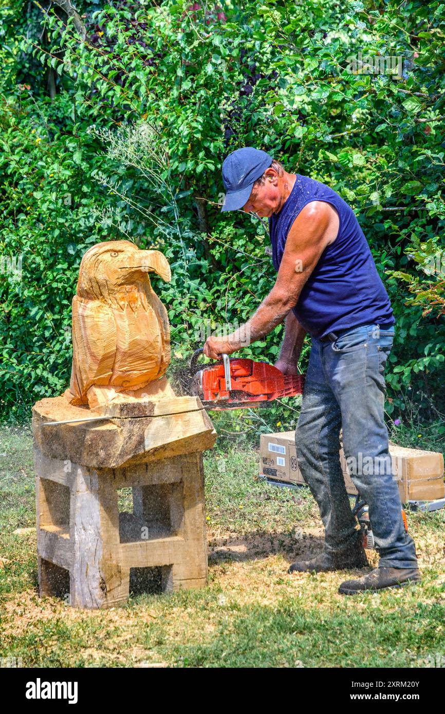 Handwerker, der die Oregon DuraCut Kettensäge verwendet, um Skulpturen aus Baumstämmen auf der Country Fair in Zentralfrankreich herzustellen. Stockfoto
