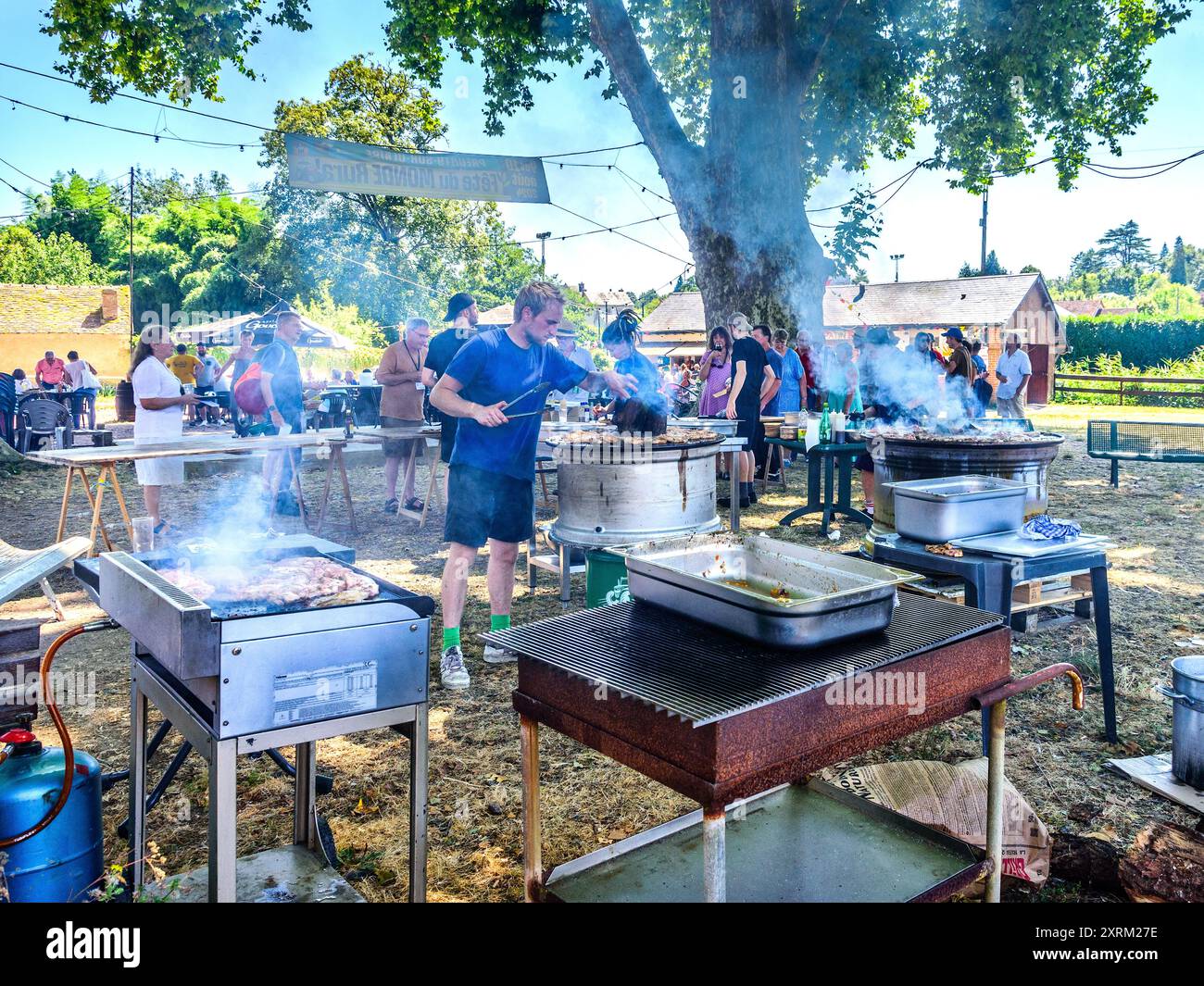 Zubereitung von Grillgerichten mit Stahlfelgen zum Kochen auf der Dorfmesse in Zentralfrankreich. Stockfoto