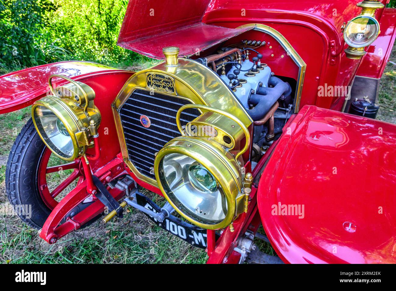 Peugeot-Oldtimer mit Radiator und Scheinwerfern aus poliertem Messing und offener Motorhaube mit Motor – Frankreich. Stockfoto