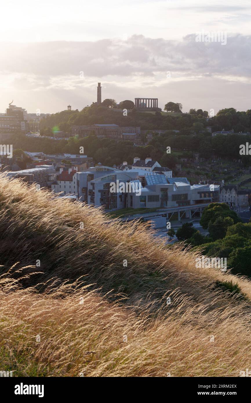 Blick auf die Salisbury Crags in Richtung Calton Hill mit National und Nelsons Monument. Schottisches Parlament im Vordergrund. Edinburgh, Schottland, 10. August 2024 Stockfoto