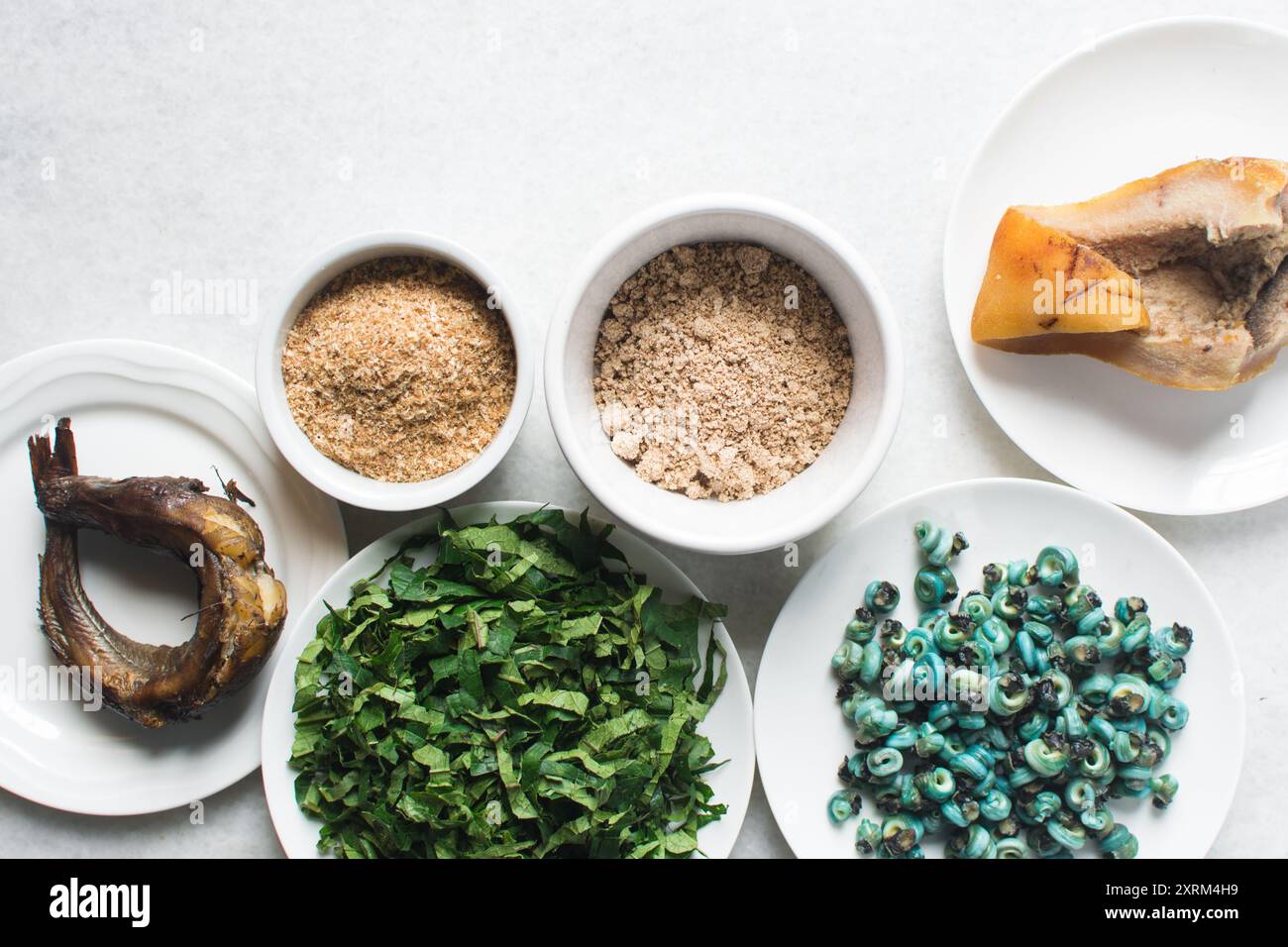 Overhead-Ansicht der Zutaten für die Zubereitung von Ogbono-Suppe auf einer Granitarbeitsfläche, Draufsicht der Miese und anstelle der Zutaten für die Zubereitung von Ogbono- und Okro-Suppe, Stockfoto