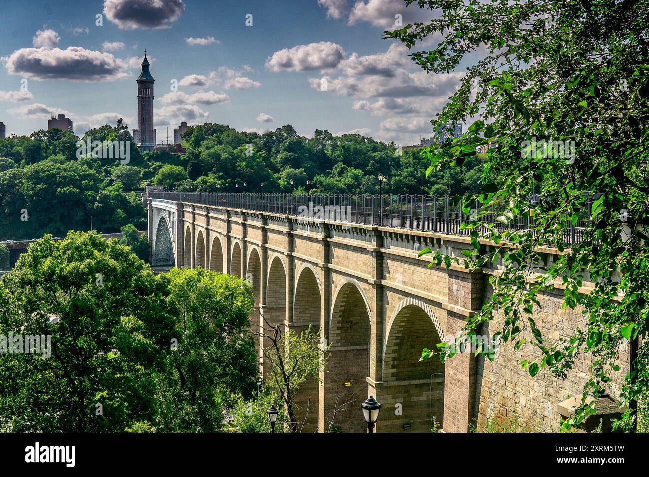 Bronx, NY - USA - 10. August 2024 die High Bridge, die älteste stehende Brücke von NYC, erstreckt sich über üppiges Grün unter hellem Himmel. Der Turm in der Ferne Stockfoto