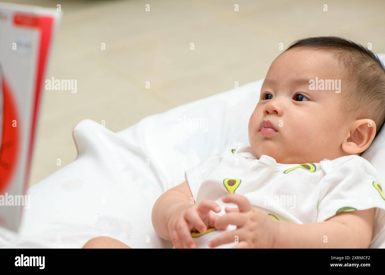 Das Baby hört aufmerksam auf die Gute-Nacht-Geschichte. Das Erzählen von Geschichten ist eine großartige Möglichkeit, die Entwicklung von Kindern zu fördern. Stockfoto