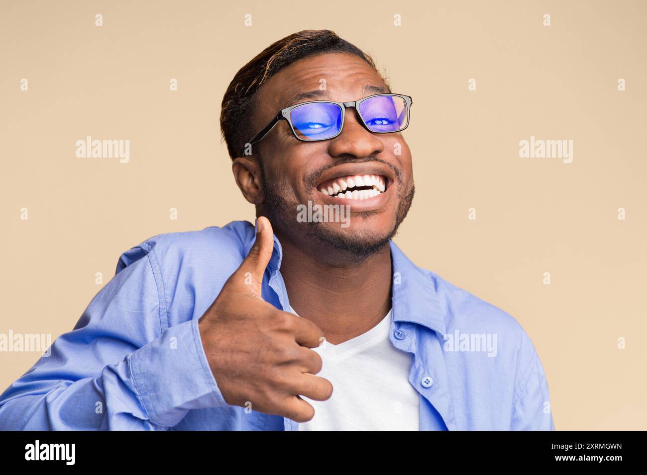 Lustige Schwarzer Mann deutete Daumen hoch stehend, Studio Shot Stockfoto