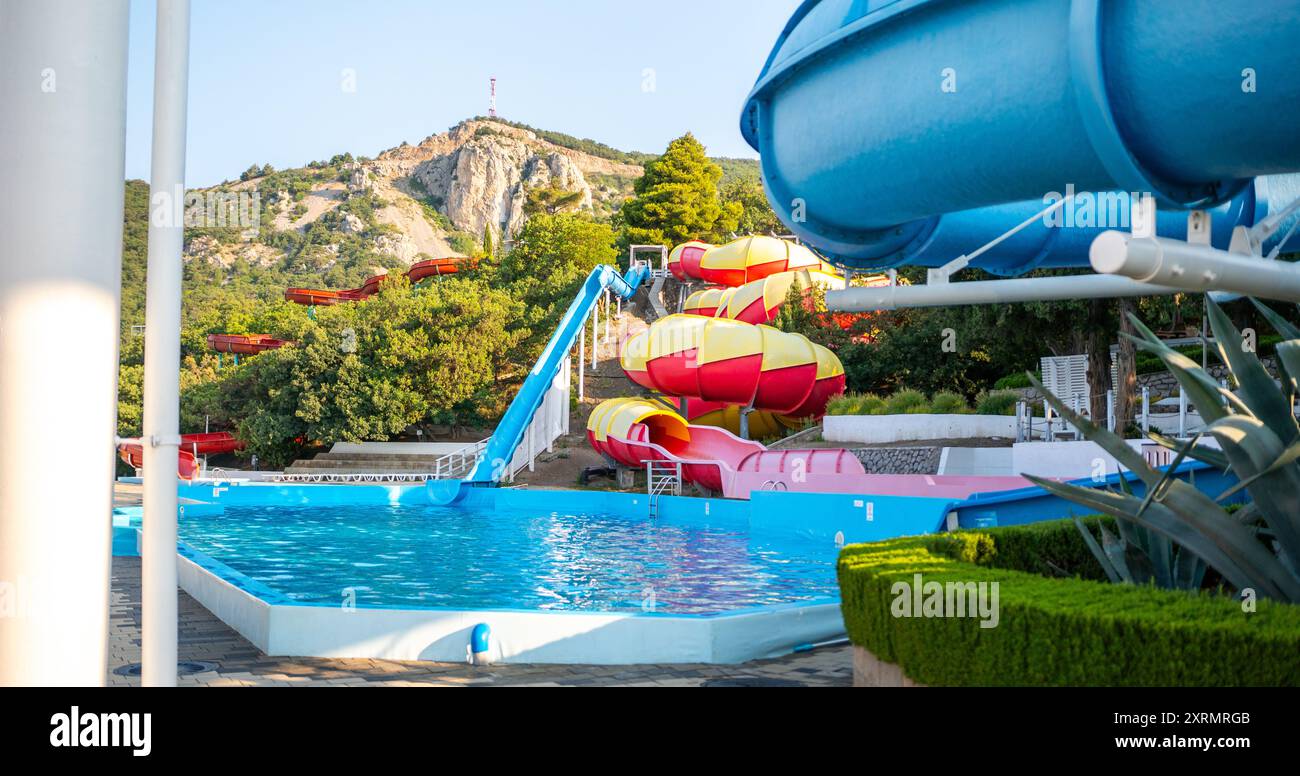 Waterpark Slides Pool Sommer: Ein Blick auf farbenfrohe Wasserrutschen in einem Wasserpark in sonniger Sommerumgebung. Stockfoto Waterpark Slides Pool Sommer: Ein Blick auf farbenfrohe Wasserrutschen in einem Wasserpark in sonniger Sommerumgebung. Stockfoto
