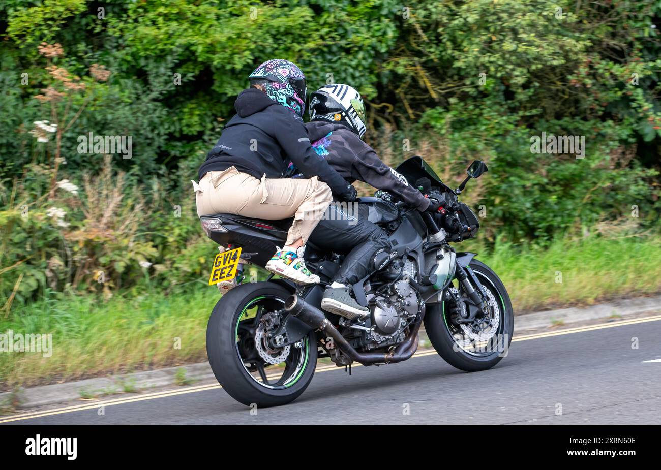 Potterspury, Northants, UK - 11. August 2024: Mann und Sozius, der auf einem schwarzen 2014er Kawasaki ZX 636 Motorrad auf einer britischen Straße fährt Stockfoto