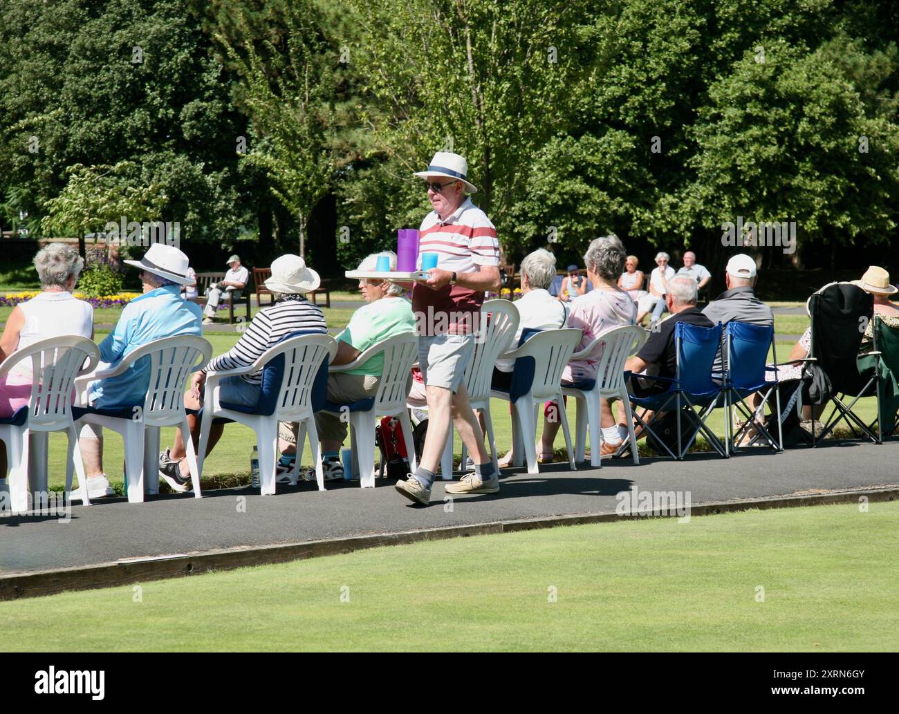 Ein Mann, der den Zuschauern beim Bowlingwettbewerb Getränke schenkt Stockfoto