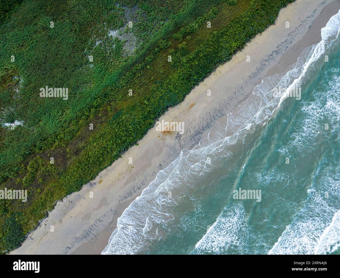 Drohnenblick auf die Wellen der Nordsee, die am Strand von Slettestrand, Jütland, Norddänemark brechen Stockfoto