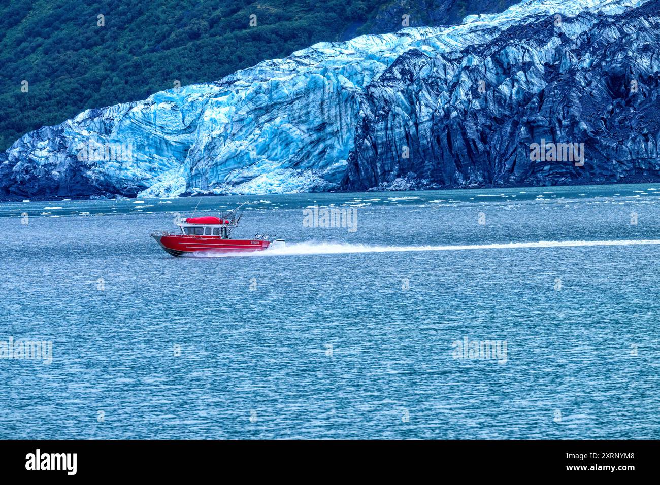 Rotes Fischerboot, das am Harvard-Gletscher im College Fjord, Prince William Sound, Alaska vorbeifährt. Stockfoto
