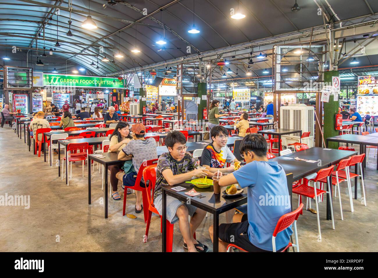 Gäste sitzen und essen im JJ Garden Food Court in Tanjung Bungah, Penang, Malaysia Stockfoto