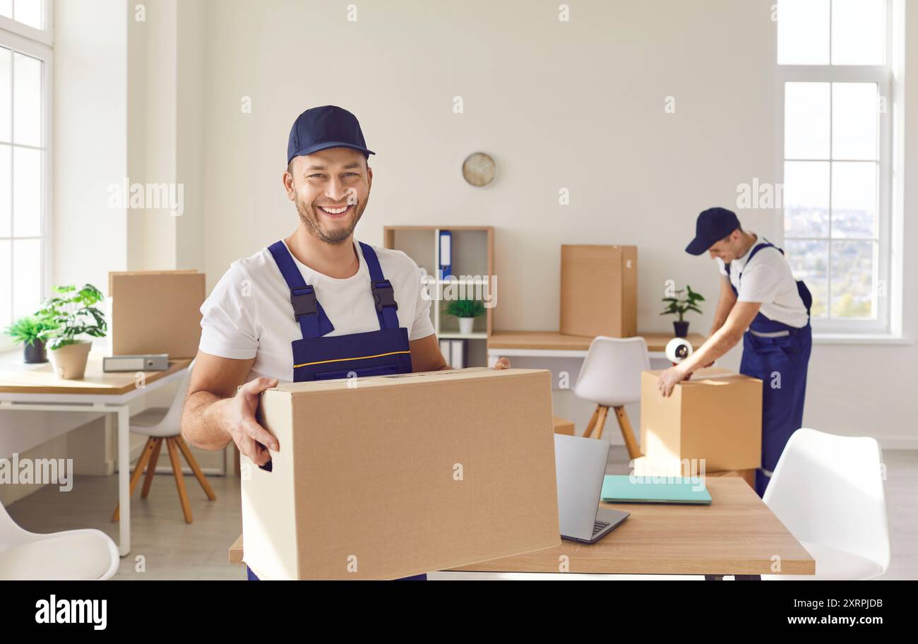Happy Movers männliches professionelles Team im Be-, Packen- und Entladen von Overalls Stockfoto