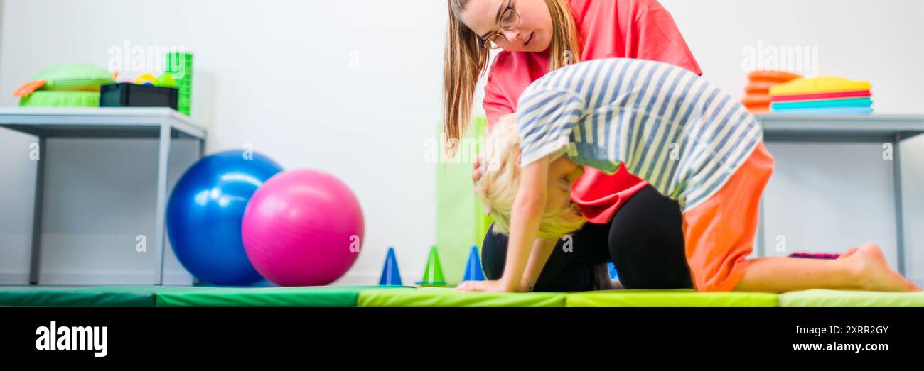 Junge beim Training mit Physiotherapeutin während der Therapiesitzung. Ergoskopische Therapie des Kindes. Bilaterale Koordinierung. Stockfoto