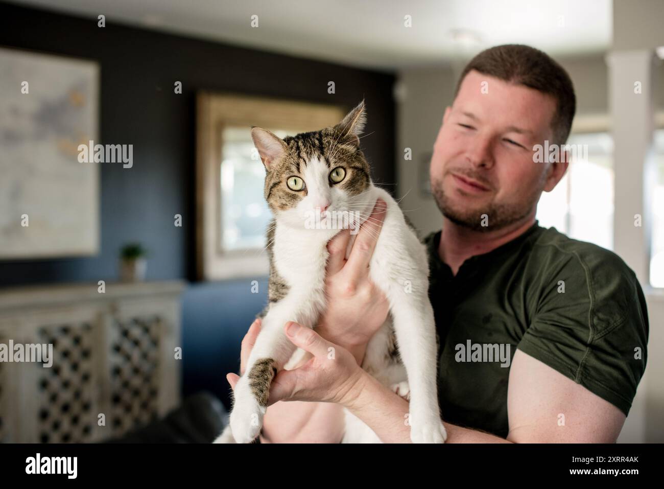 Mann hält Katze zu Hause Stockfoto