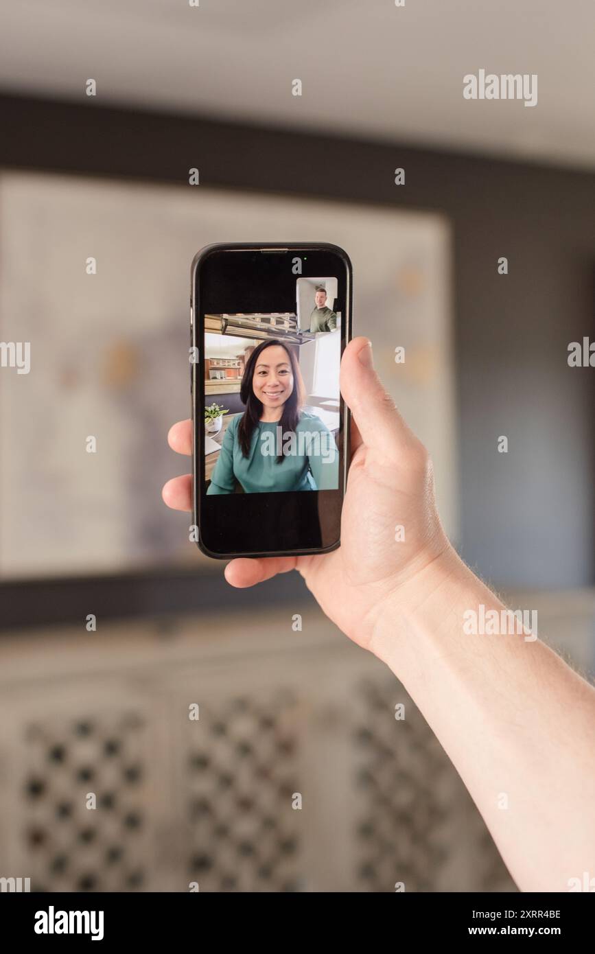 Zoom-Anruf auf Handy mit Mann und Frau Stockfoto