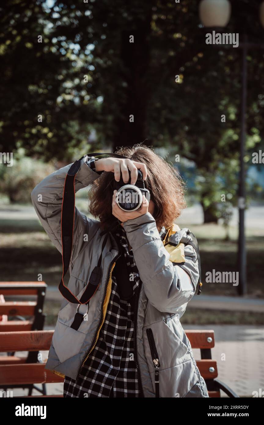 Fotografin mit braunen lockigen Haaren macht Fotos von dir Stockfoto