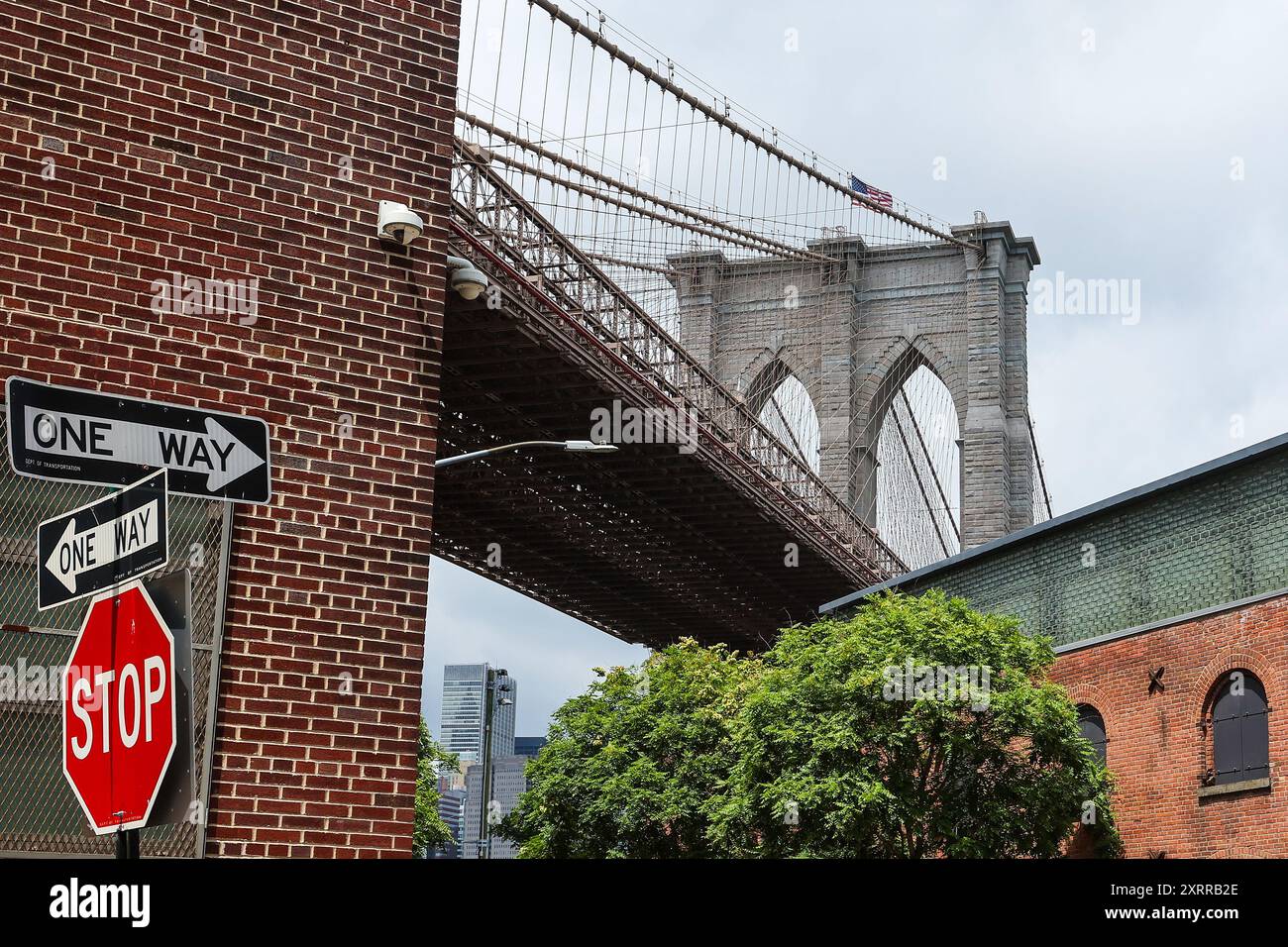 Allgemeine Sicht von unten auf die Brooklyn Bridge auf der Brooklyn-Seite des East River mit einem Stoppschild in New York City, New York, USA Stockfoto